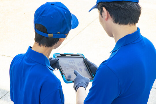 タブレットを見て相談する作業員 - Powered by Adobe