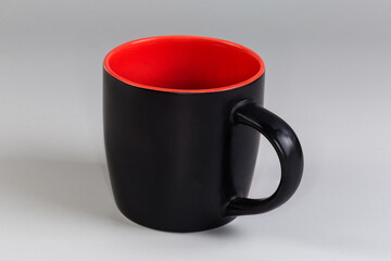 Empty cup black outside and red inside, side view