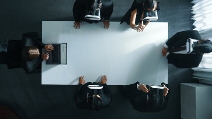 Top down aerial view of professional business team wear vr headset to enter virtual world while sitting and using hand gestures to manipulate the data from the manager laptop. Technology. Directorate.