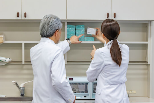 Technician in white coat checking the shelves