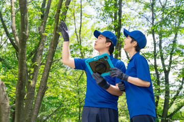 タブレットを使って森林を調査する作業員