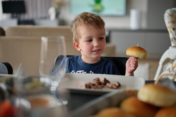 Little toddler sitting at the table during lunch
