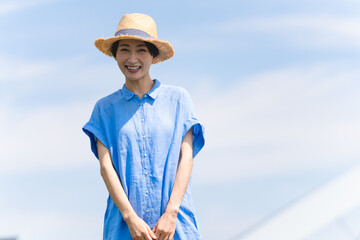 麦わら帽子をかぶって散歩する若い女性　ライフスタイルイメージ