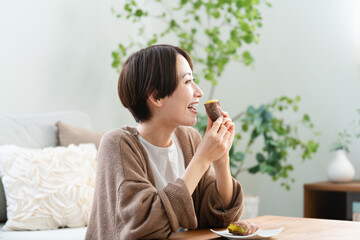 焼き芋を食べる若い女性　ライフスタイルイメージ