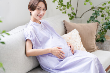 ソファーでくつろいでいる妊婦　ライフスタイルイメージ