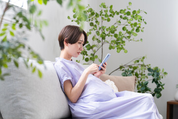 スマートフォンを操作する妊婦　ライフスタイルイメージ