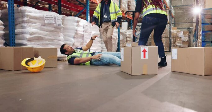 Accident, warehouse and employees helping man with leg pain for working with heavy cardboard boxes. Ecommerce, freight and factory worker on floor with muscle sprain and medical emergency with team. - Powered by Adobe