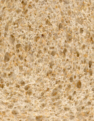 Slice of  high fibre brown wholemeal bread close up texture detail background