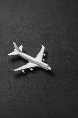 A small white airplane is sitting on a black surface