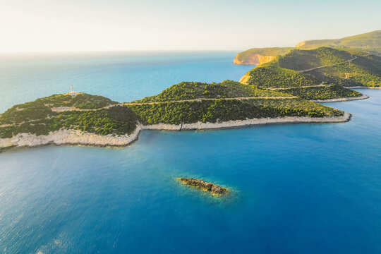 Lighthouse on the cliff. Seascape of Cape Lefkatas with old lighthouse on Lefkada island, Greece. Beautiful views of azure sea water and nature with cliffs