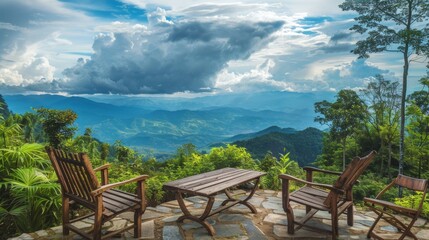 Wooden deck with rustic chairs facing a breathtaking view of misty mountains and lush forest. Dramatic cloudy sky looms overhead. 