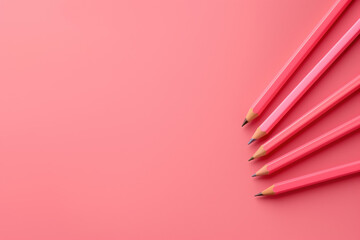 Five pink pencils pointing up and right on pink background