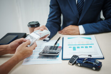 A businessman holds the key to success in car finance, focusing on sales, insurance, and investment. He manages contracts and agreements in a dynamic auto dealership environment
