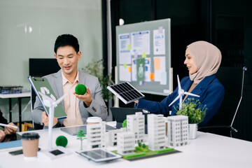 Group of diverse multiethnic businesspeople standing neare table looking at model of building from...