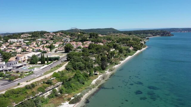 Aerial view drone video flying from the air over the picturesque sea coast of the south of France, Provence, Istres at bright sunny summer day