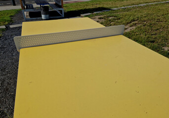 plastic tables and table tennis in the park with a threshing floor and benches. The tables are wind...
