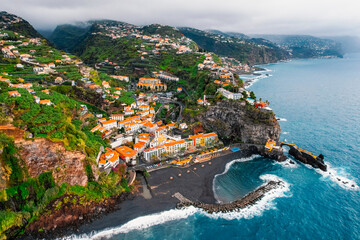 Aerial view of rough ocean with waves, volcanic beach in Ponta do Sol, Madeira, Portugal