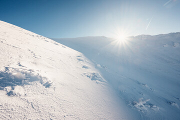 Alpine mountains landscape with white snow and blue sky. Sunset winter in nature. Frosty trees under warm sunlight. Wonderful wintry landscape. Low Tatras, Slovakia