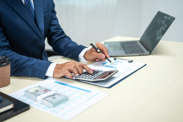 A banker in a suit works at a desk handling loans, analyzing client financial data, providing...