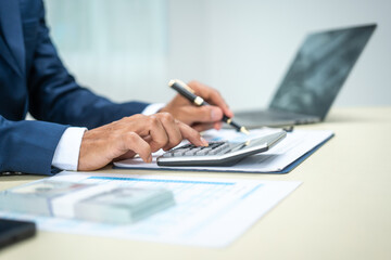 A banker in a suit works at a desk handling loans, analyzing client financial data, providing...