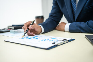 A banker in a suit works at a desk handling loans, analyzing client financial data, providing...