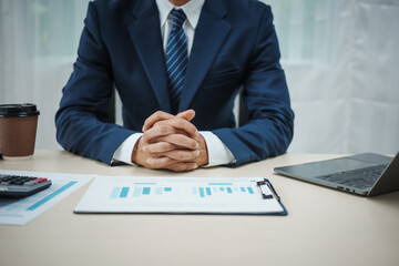 A banker in a suit works at a desk handling loans, analyzing client financial data, providing...