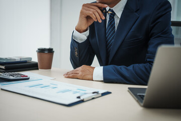 A banker in a suit works at a desk handling loans, analyzing client financial data, providing...