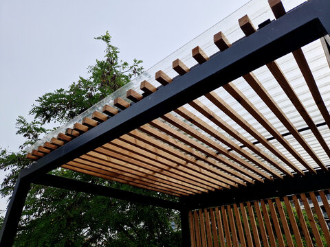 modern market stand made of metal pergola structure with slats on the sides of the walls. the striped appearance of the smoking shelters at the bus stop