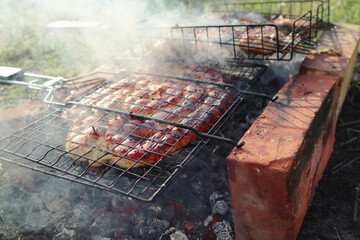 Coil of spicy beef sausage grilling on a fire. Delicious grilled sausage. Spirals sausage grilling on a BBQ