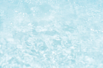 Obraz premium Blue water with ripples on the surface. Defocus blurred transparent blue colored clear calm water surface texture with splashes and bubbles. Water waves with shining pattern texture background.