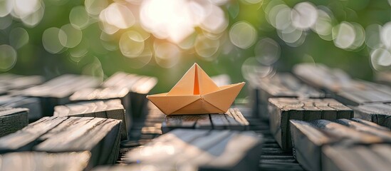 Origami paper boat passes through the wooden cube barriers. To overcome obstacles or barriers in business or education concept. Copy space image. Place for adding text or design