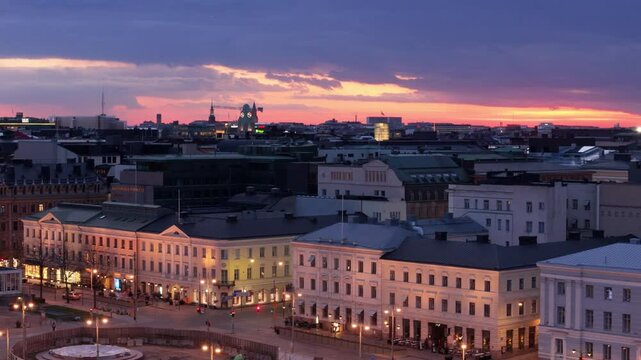 Iconic Helsinki waterfront buildings illuminated at twilight, aerial trucking