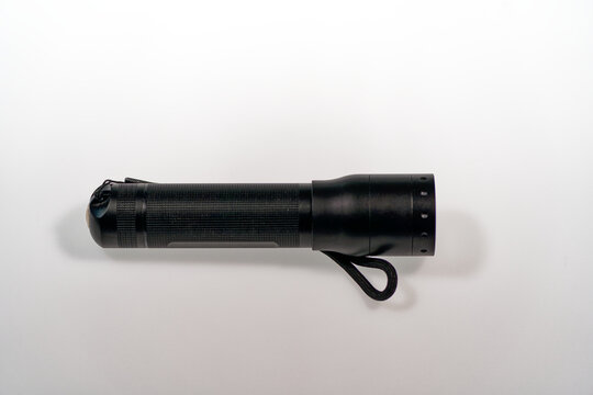 Close-up of black metal flashlight led model Lenser P7R against white background. Photo taken June 22nd, 2024, Zurich, Switzerland.