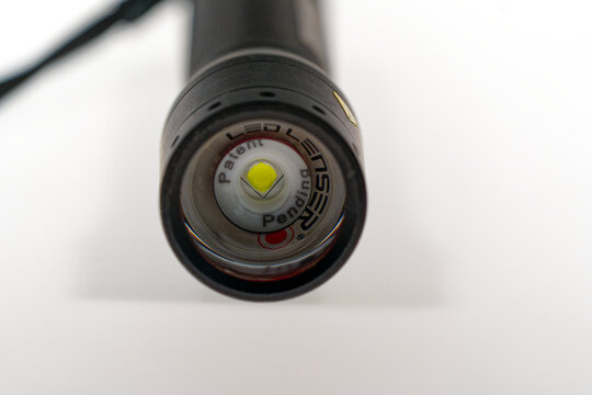 Close-up of black metal flashlight led model Lenser P7R against white background. Photo taken June 22nd, 2024, Zurich, Switzerland.