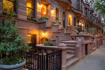 Evening view of iconic New York City brownstones with stoop steps on Upper West Side of Manhattan....