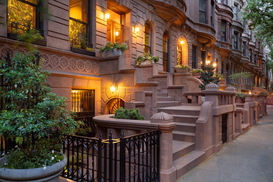 Evening view of iconic New York City brownstones with stoop steps on Upper West Side of Manhattan. This row of brownstones is located in Central Park West Historic District