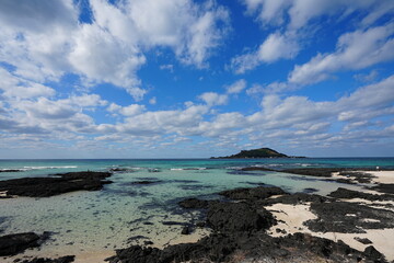 clear shoaling beach and fine clouds