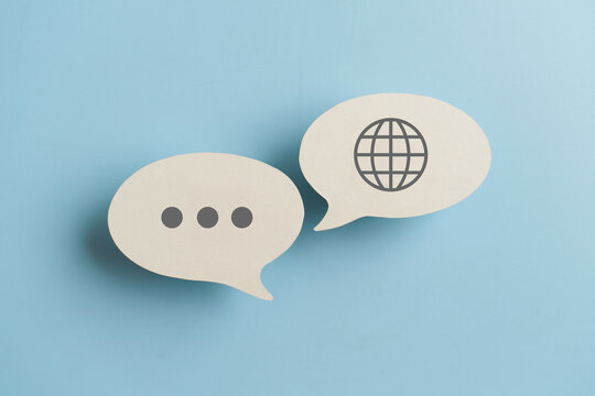 For translator application,  foreign languages concept, top view of real  white speech bubble paper with  on blue background