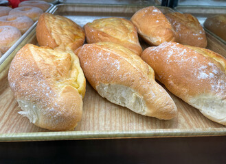 A tray with Mexican bolillos or birotes on display at a Mexican bakery.