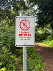 Sign in the forest with the inscription Leave no trace. Pack out what you pack in
