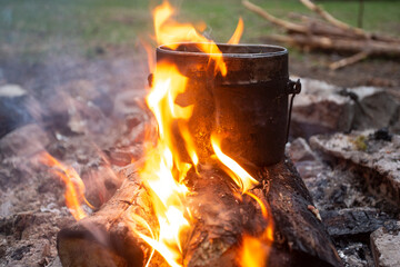 Cooking food over a campfire in a camp pot.