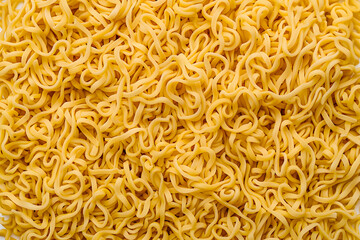 Close-up of uncooked, curly instant noodles. Perfect for food backgrounds and culinary themes. High-resolution stock photo.