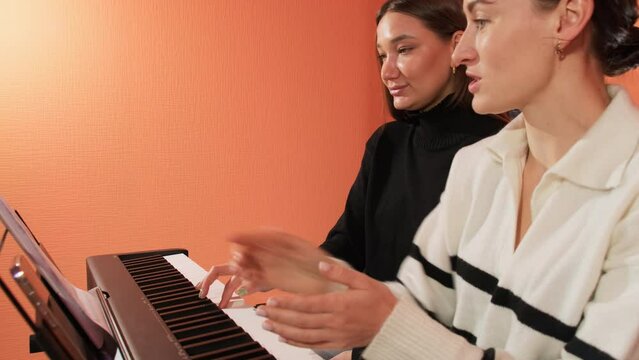 Coach claps hands while student plays notes of etude. Guidance and feedback provided by teacher serve as invaluable assets