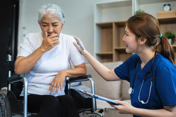 young caregiver assists her elderly woman patient at a nursing home. senior woman is assisted by a...