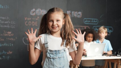 Girl smile and wave to camera while friend working or learning engineering code or prompt in STEM...