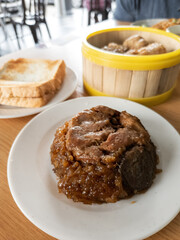 Glutinous rice with soy sauce cooked together with chicken parts and eat with chop stick.