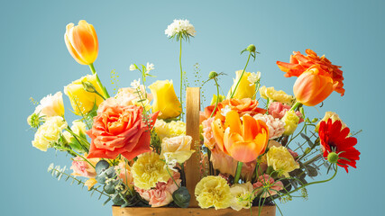 Flowers in basket, closeup, orange and yellow roses, tulip and carnation on blue background
