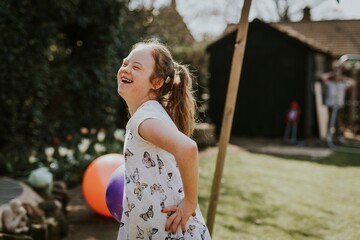 Cheerful girl with Down Syndrome playing in the backyard