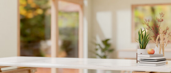 A white tabletop features decorative objects with a blurred background of a minimalist room.