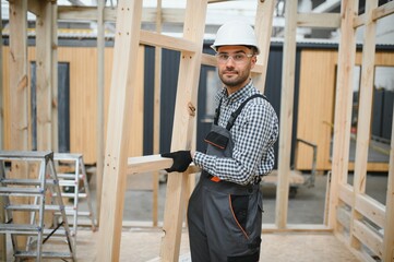 Process of construction new and modern modular house. Worker man in special protective uniform wear working on building development industry of energy efficient property
